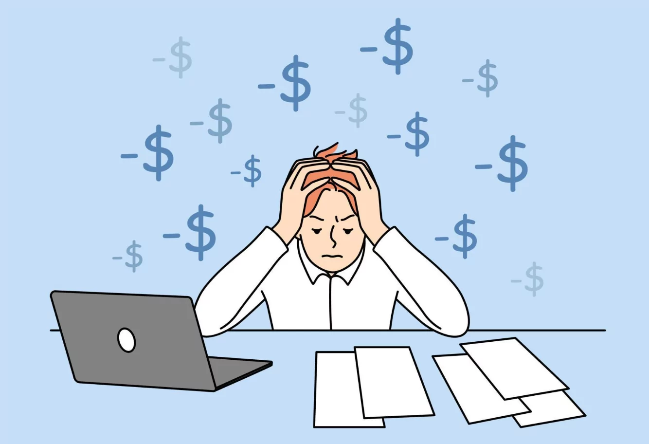 Person sitting at a desk with a laptop and a coffee cup, reviewing a digital financial planner during a monthly money date session